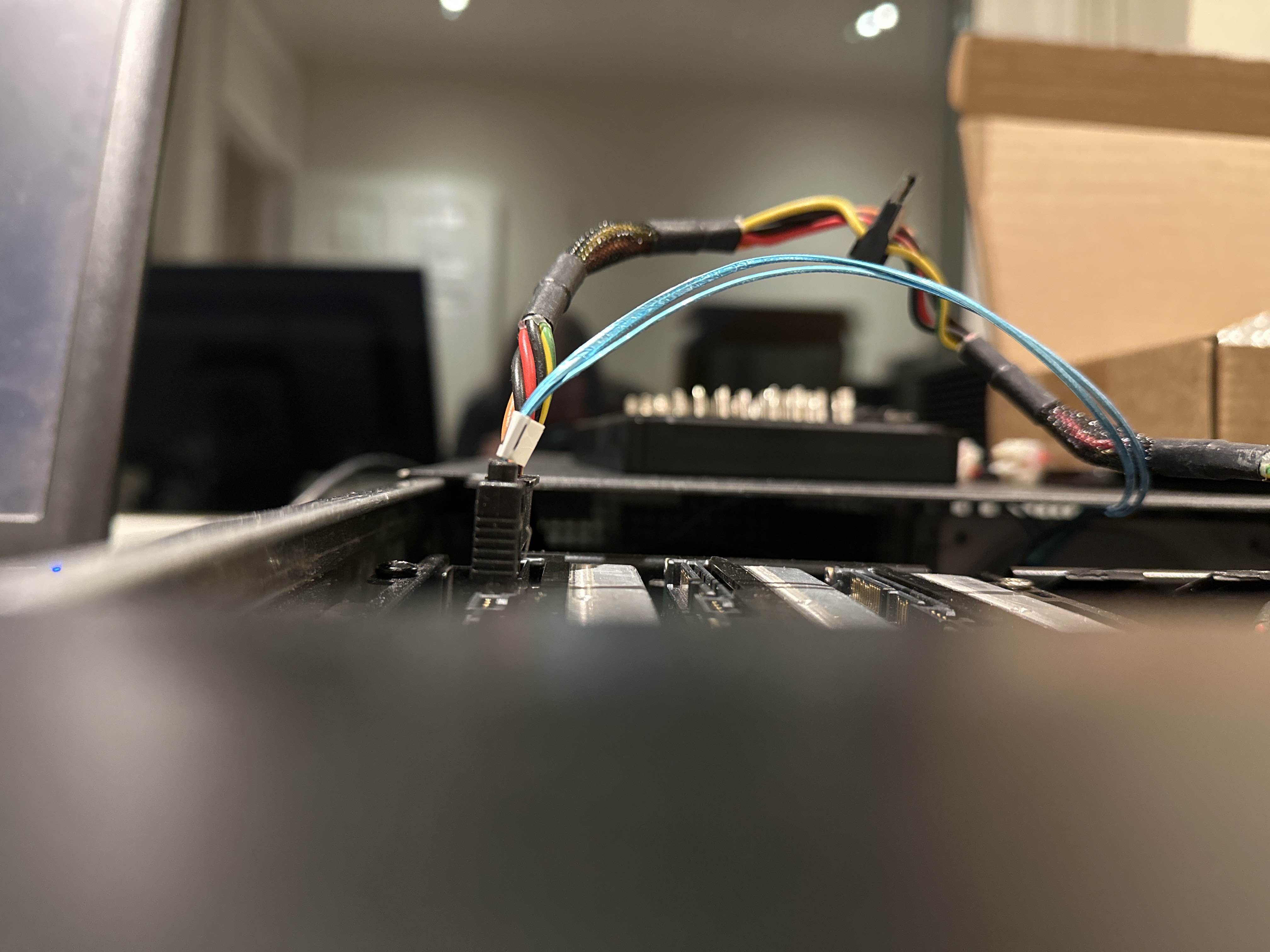 Photograph of sata power and data cables connected to a hard drive. It is apparent that they are too tall to allow the case lid to close. The background is out of focus, but shows an office.
